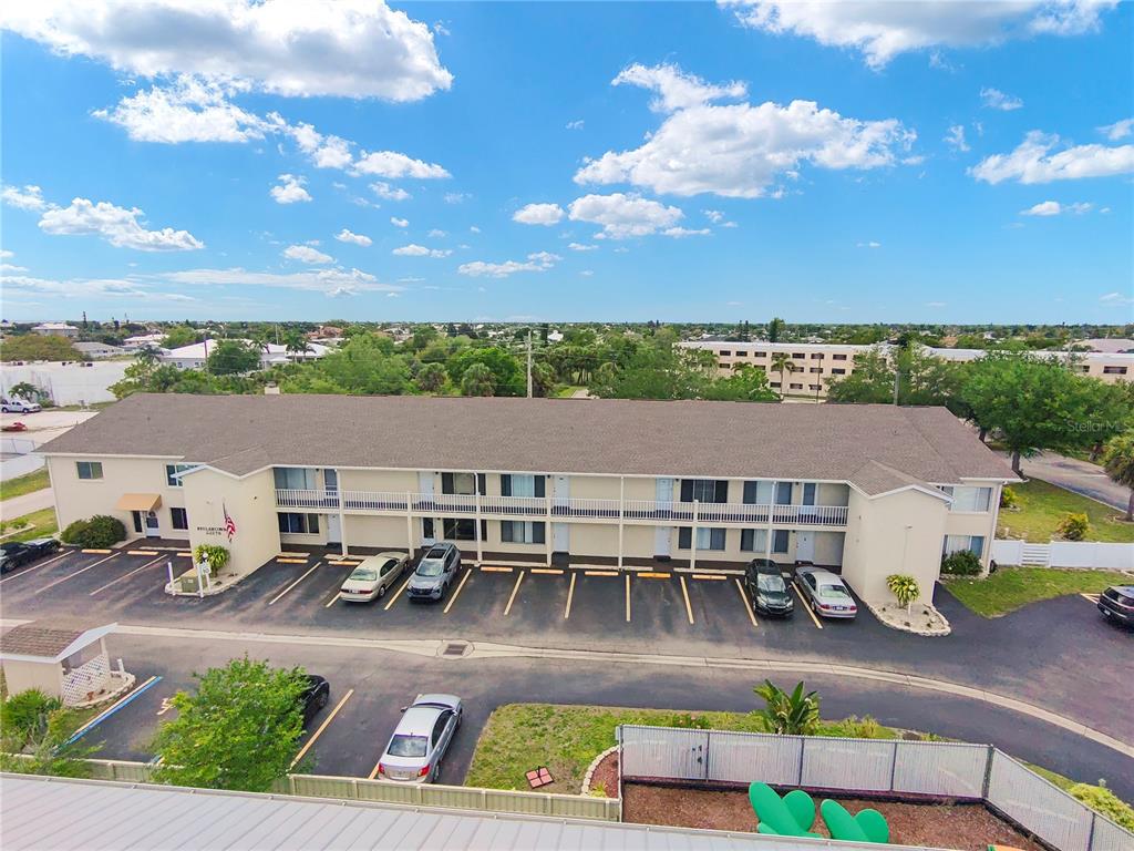 An aerial view of a two-story apartment building with a parking lot in front — 22278 VICK STREET UNIT A112, PUNTA GORDA, FL