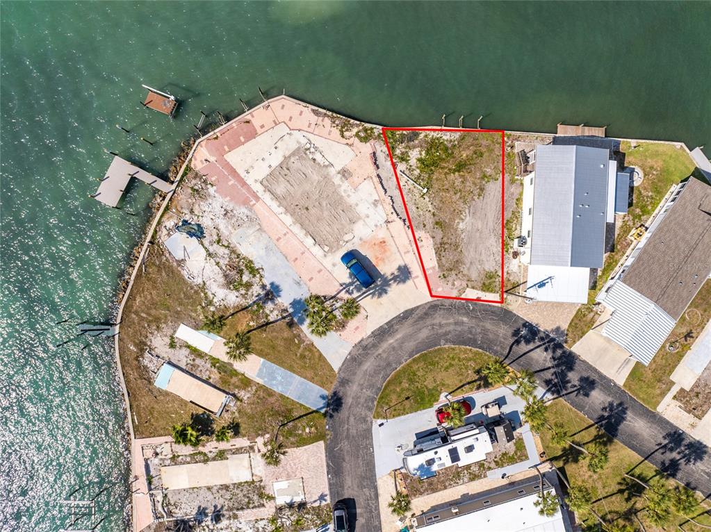 An aerial view shows a vacant waterfront lot outlined in red next to existing homes — 7500 PARK POINTE DRIVE UNIT 42, ENGLEWOOD, FL