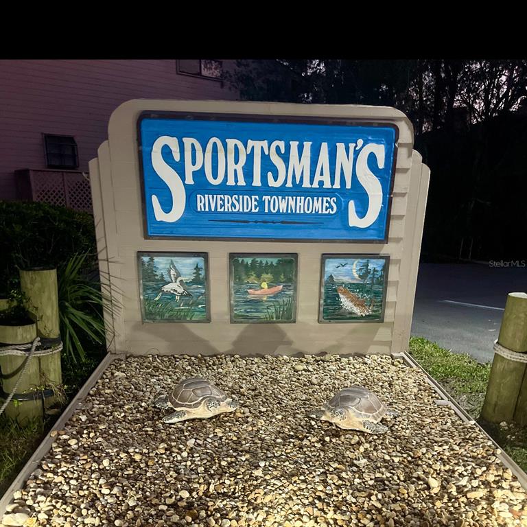 A sign for Sportsman's Riverside Townhomes features three small paintings and two decorative turtle statues — 5111 S GRAY PELICAN WAY UNIT 5111, HOMOSASSA, FL