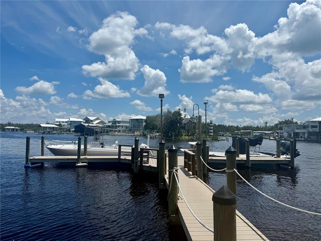 A wooden boat dock extends into a river with boats moored on both sides — 5111 S GRAY PELICAN WAY UNIT 5111, HOMOSASSA, FL