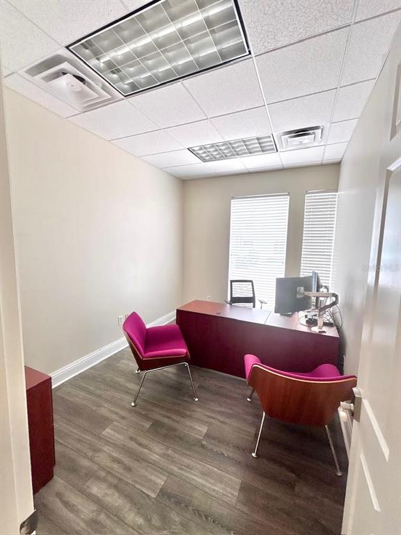 An office features a dark red desk, two pink chairs, and wood-look flooring — 1550 W CLEVELAND STREET UNIT 2, TAMPA, FL
