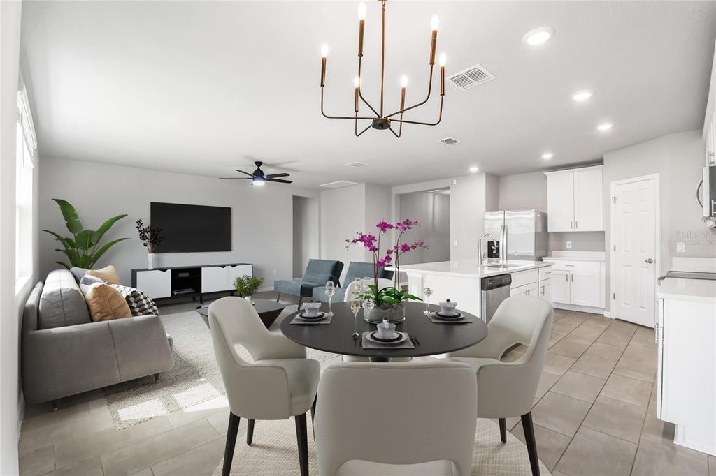 An open-concept living and dining area features a modern kitchen with white cabinetry and tile — 17413 BACK BAY COURT, CLERMONT, FL