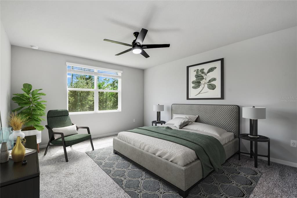 This bedroom features a gray upholstered bed, a green accent chair, and a ceiling fan — 17413 BACK BAY COURT, CLERMONT, FL