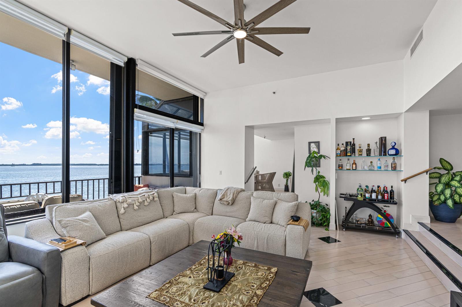 A living room with a large sectional sofa, a coffee table, and a built-in bar — 520 Brickell Key Drive # A200, Miami FL 33131, MIAMI, FL