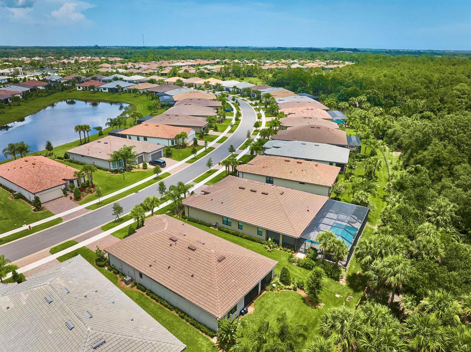 A single-story house exterior features a gray garage door, tiled roof, and paver driveway — 3862 White Alder Way, Vero Beach FL 32967, VERO BEACH, FL