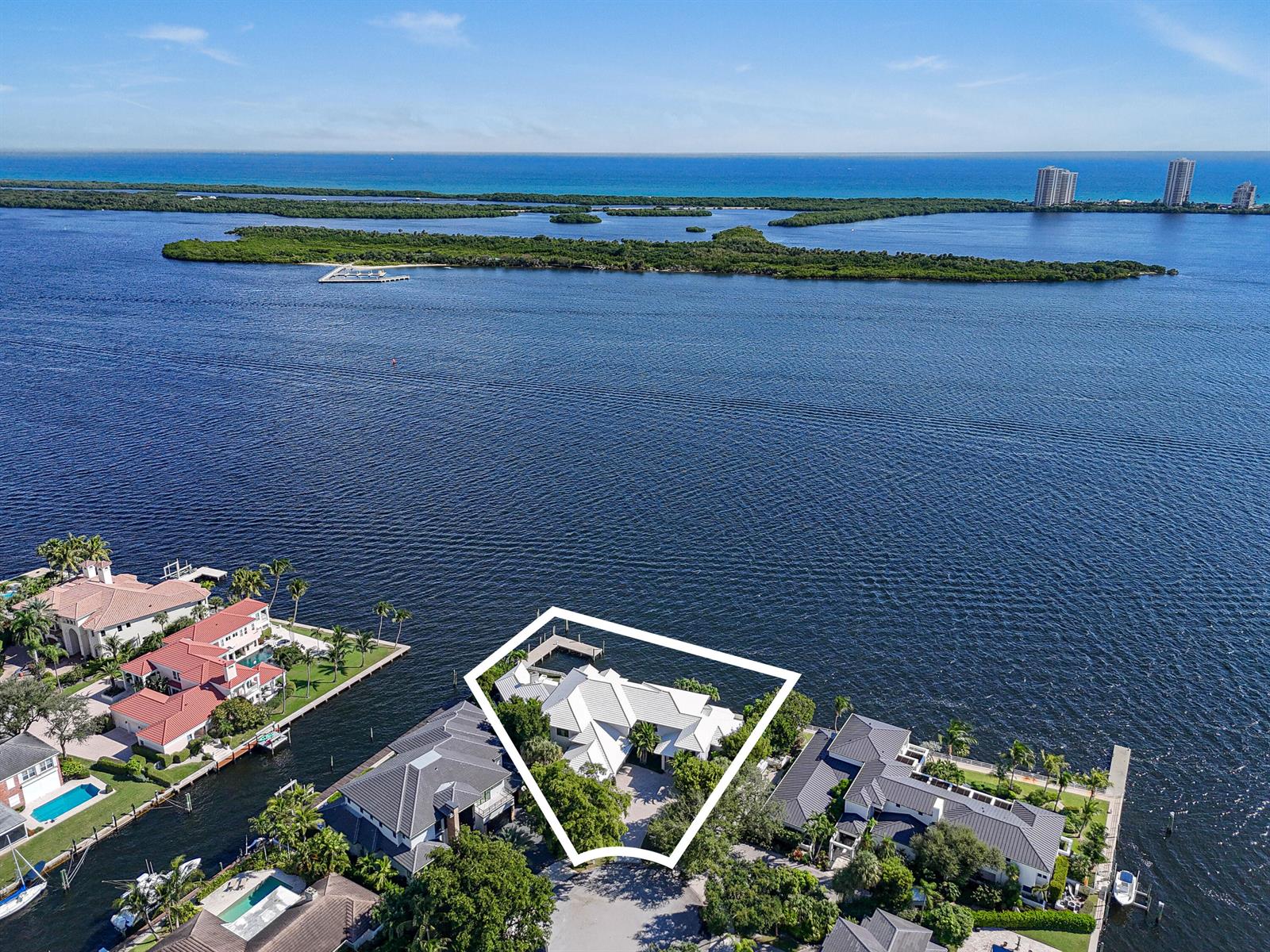 An aerial view shows a waterfront house with a white roof and a private dock — 101 Bowsprit Drive, North Palm Beach FL 33408, NORTH PALM BEACH, FL