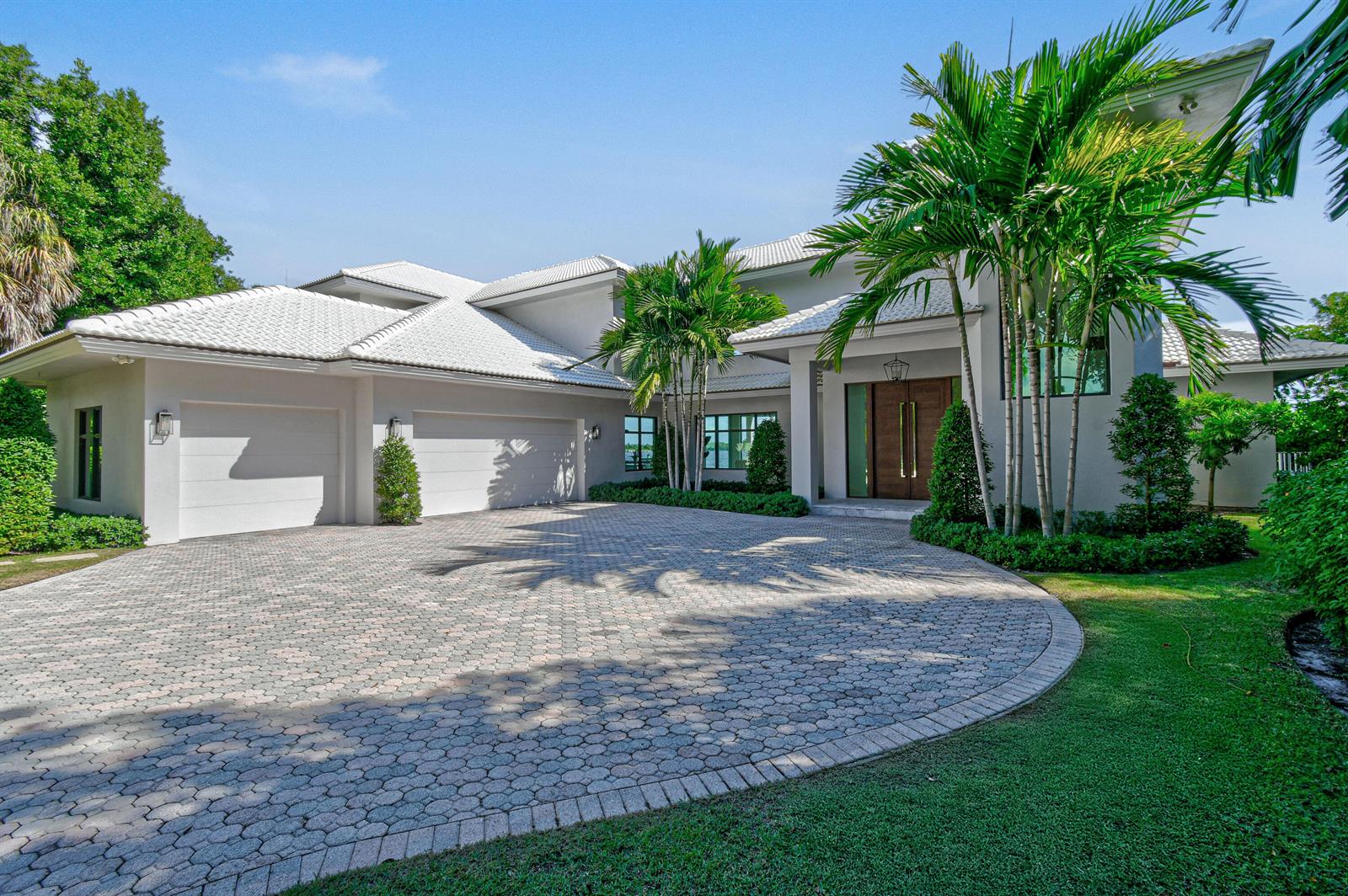 A modern two-story house with a white tile roof, palm trees, and a paved circular driveway — 101 Bowsprit Drive, North Palm Beach FL 33408, NORTH PALM BEACH, FL