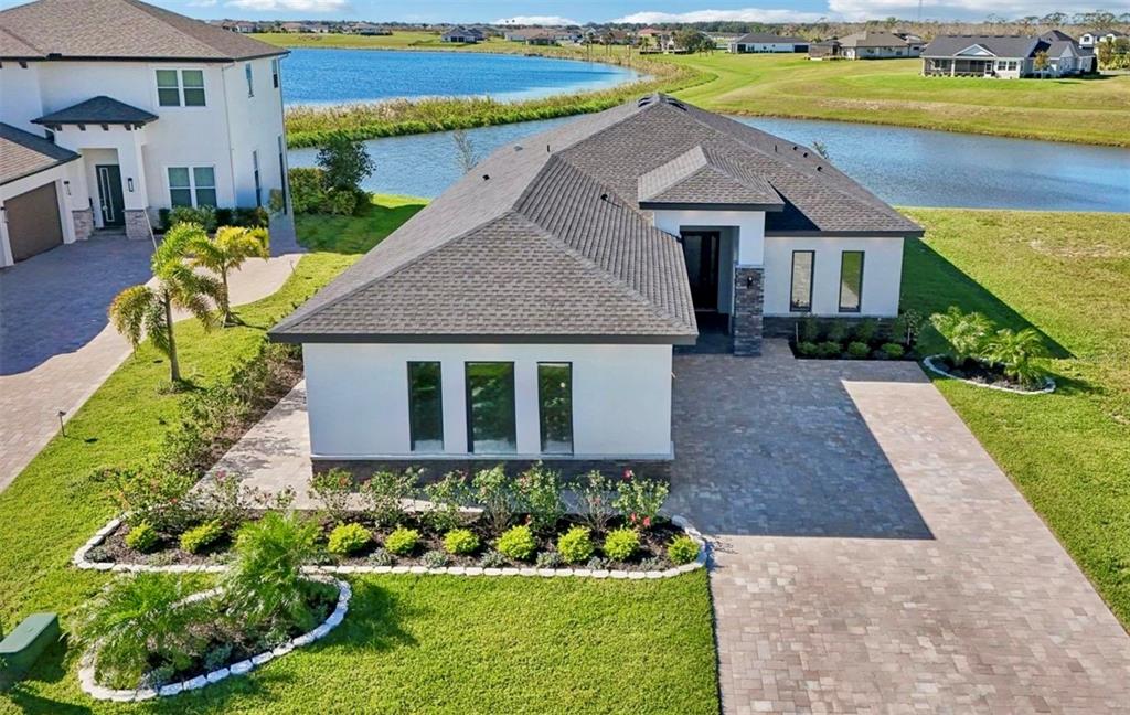A modern single-story house with a stone-accented facade, a paved driveway, and a garage — 224 VALENCIA RIDGE DRIVE, AUBURNDALE, FL