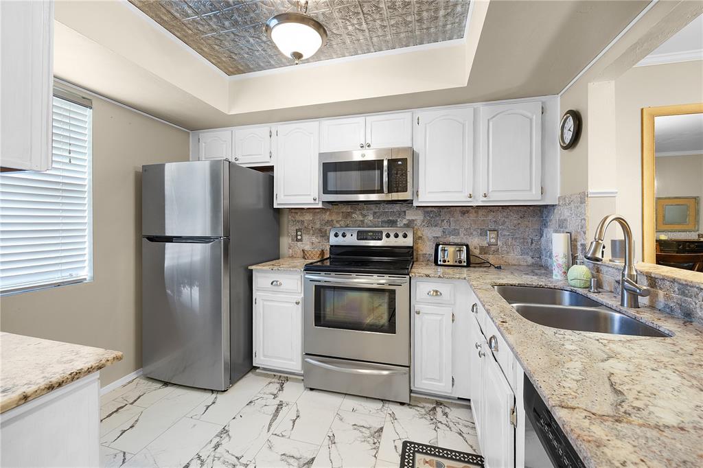 A kitchen with white cabinets, stainless steel appliances, granite countertops, and a patterned ceiling — 1001 PINE ISLE LANE UNIT 1001, NAPLES, FL