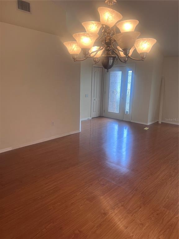 An empty living room features light-colored walls, wood-look flooring, vertical blinds, and a ceiling fan — 924 RIDGE HAVEN DRIVE, BRANDON, FL