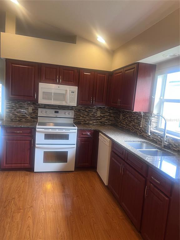 A kitchen features a stainless steel refrigerator, dark wood cabinets, and a tiled backsplash — 924 RIDGE HAVEN DRIVE, BRANDON, FL