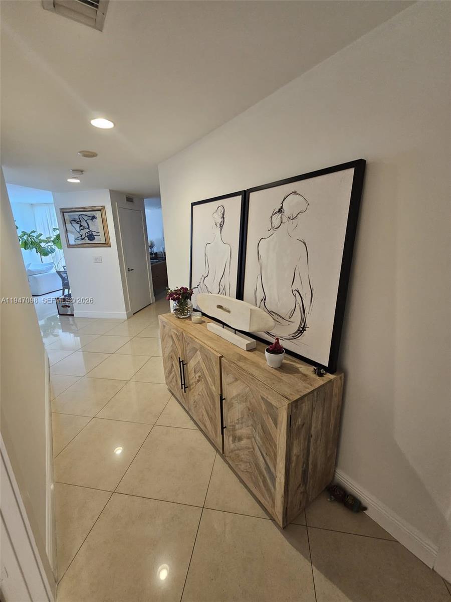 A hallway features light-colored tile floors, a wooden console table, and two framed line-art prints — 1060 Brickell Ave # 1917, Miami FL 33131, MIAMI, FL