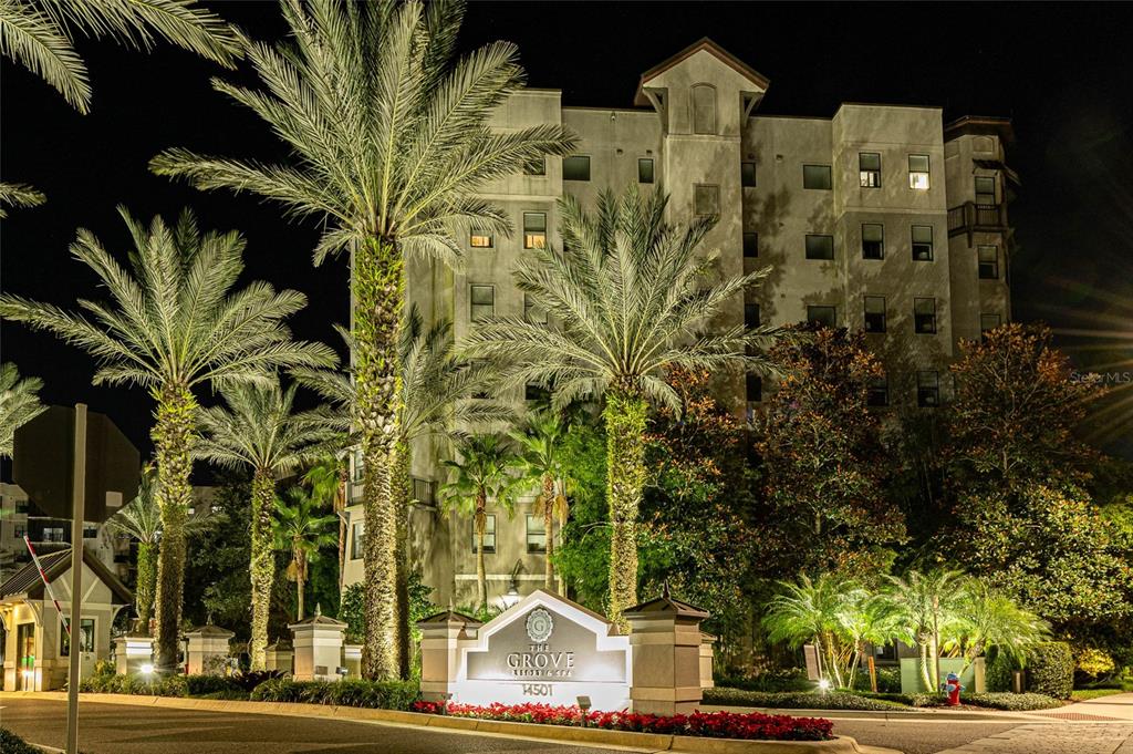 A multi-story resort building is illuminated at night behind a prominent entrance sign and palms — 14501 GROVE RESORT AVENUE UNIT 2534, WINTER GARDEN, FL