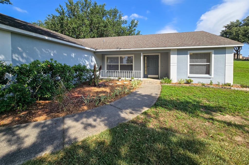 A single-story house with a gray exterior, a concrete walkway, and a front entrance — 10417 LAKE HASSON CIRCLE, CLERMONT, FL