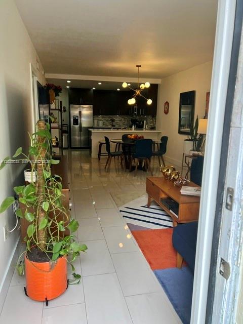 An open-concept living and dining area features a kitchen with dark cabinetry and tile floors — 1701 NE 115th st # 1A, Miami FL 33181, MIAMI, FL