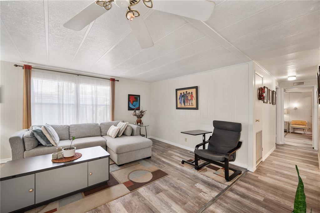 A living room features a gray sectional sofa, a coffee table, and a dark armchair — 1610 REYNOLDS ROAD UNIT 126, LAKELAND, FL