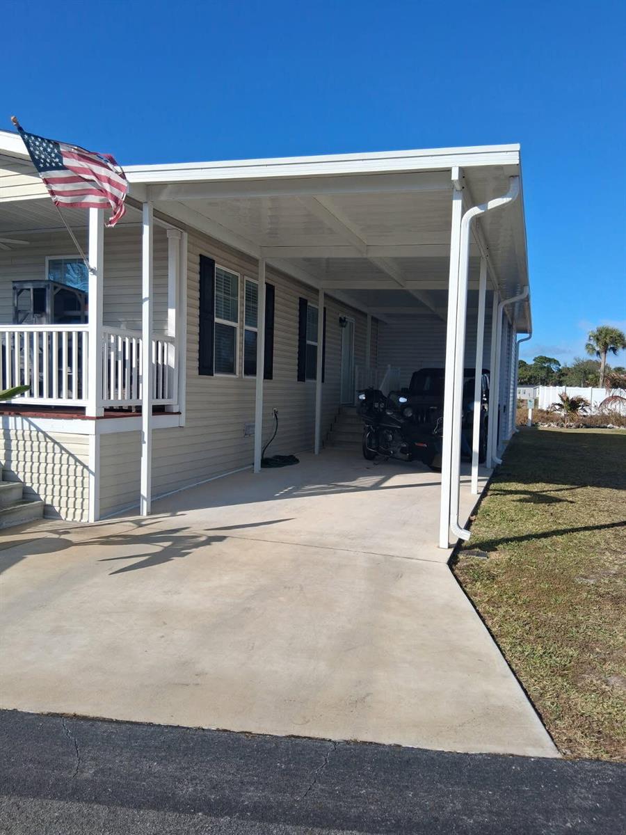 A mobile home exterior features a covered carport, a front porch, and a concrete driveway — 356 Mockingbird Avenue, Fort Pierce FL 34982, FORT PIERCE, FL