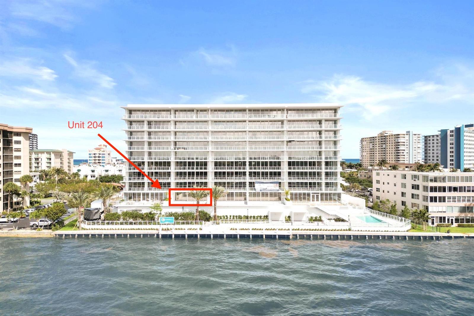 An exterior view of a multi-story waterfront apartment building with a highlighted second-floor unit — 407 N Riverside Drive # 204, Pompano Beach FL 33062, POMPANO BEACH, FL