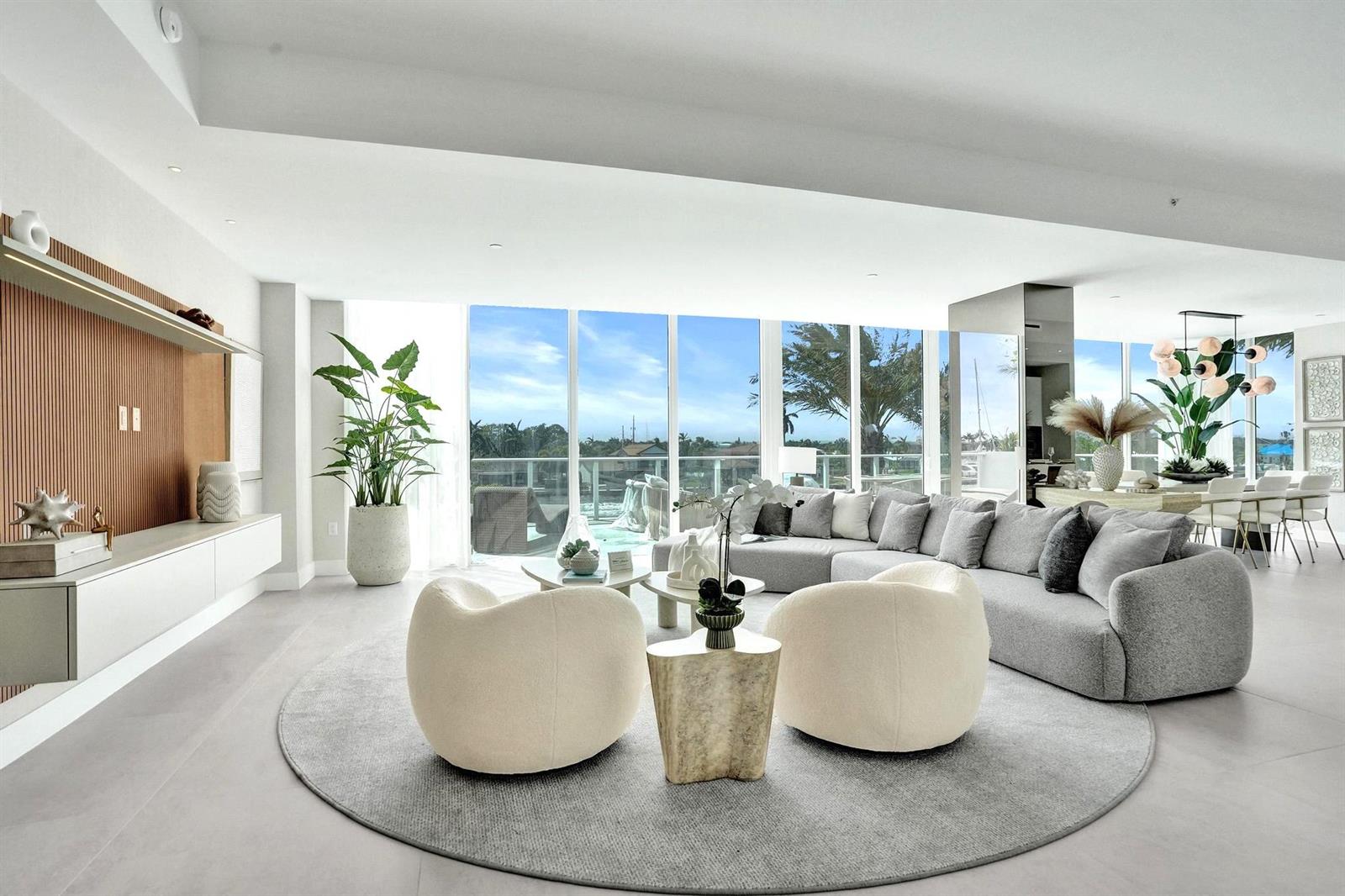 A modern living room features a large gray sectional, two cream chairs, and floor-to-ceiling windows — 407 N Riverside Drive # 204, Pompano Beach FL 33062, POMPANO BEACH, FL