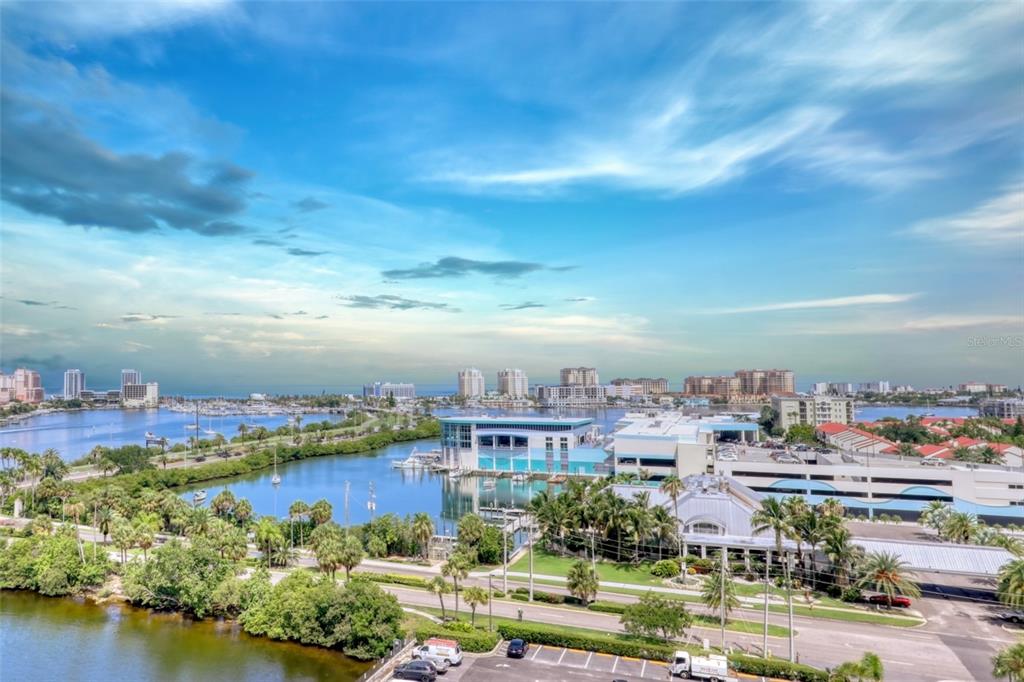 An elevated view of a coastal city with a marina, palm trees, and a parking lot — 31 ISLAND WAY UNIT 1205, CLEARWATER BEACH, FL