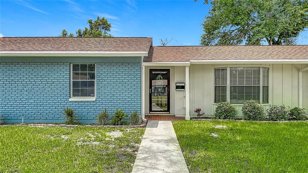 A single-story house with a blue brick facade, brown roof, and a concrete walkway — 514 W HILDA DRIVE, BRANDON, FL
