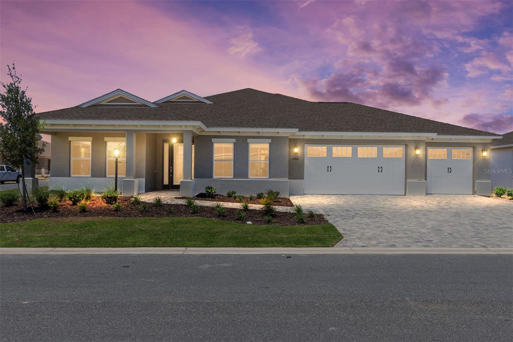 A single-story house with a gray exterior, a three-car garage, and a paved driveway — 10261 SW 82ND PLACE ROAD, OCALA, FL
