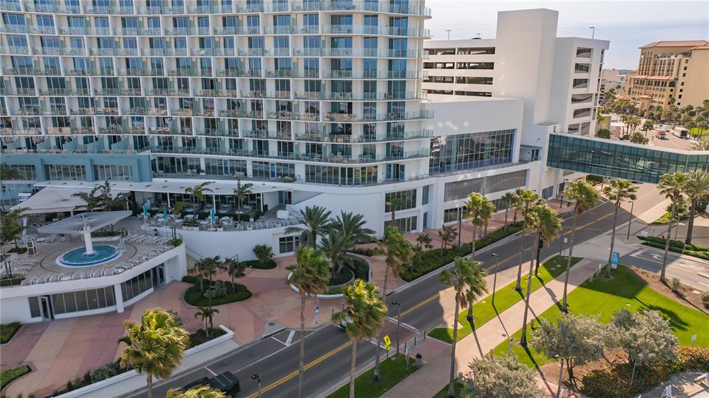An aerial view shows a large hotel building with a glass skybridge over a street — 400 CORONADO DRIVE, CLEARWATER BEACH, FL
