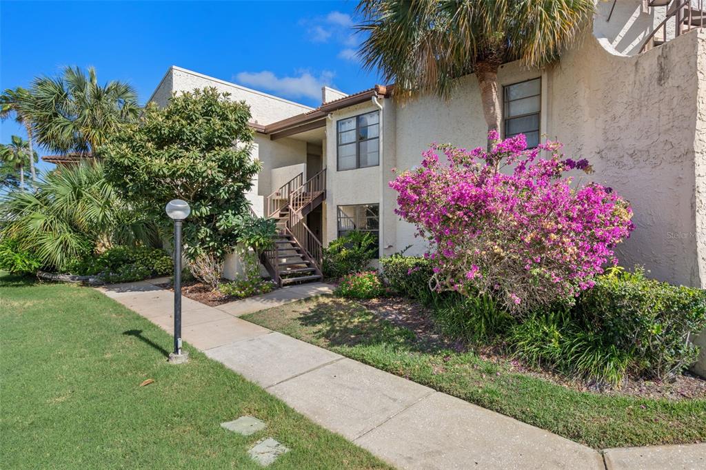 A view from a balcony overlooking a canal with docks, palm trees, and apartment buildings — 2571 CYPRUS DRIVE UNIT 1-201, PALM HARBOR, FL