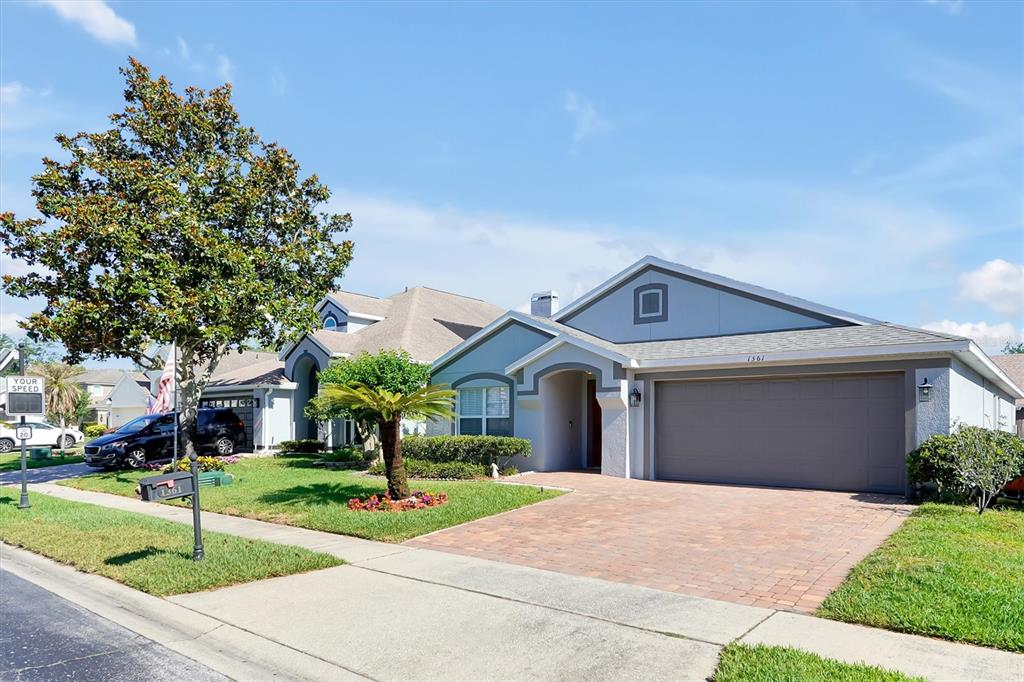 A single-story house with a brick paver driveway, a two-car garage, and a front lawn — 1361 HOLLY GLEN RUN, APOPKA, FL