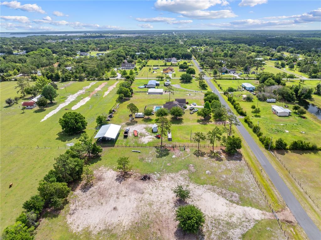 An aerial view shows a rural property with a house, pool, and several outbuildings — HUNTING LODGE DRIVE, ST CLOUD, FL