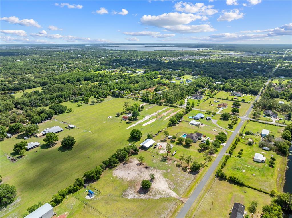 An aerial view shows a rural landscape with scattered houses, large grassy lots, and trees — HUNTING LODGE DRIVE, ST CLOUD, FL