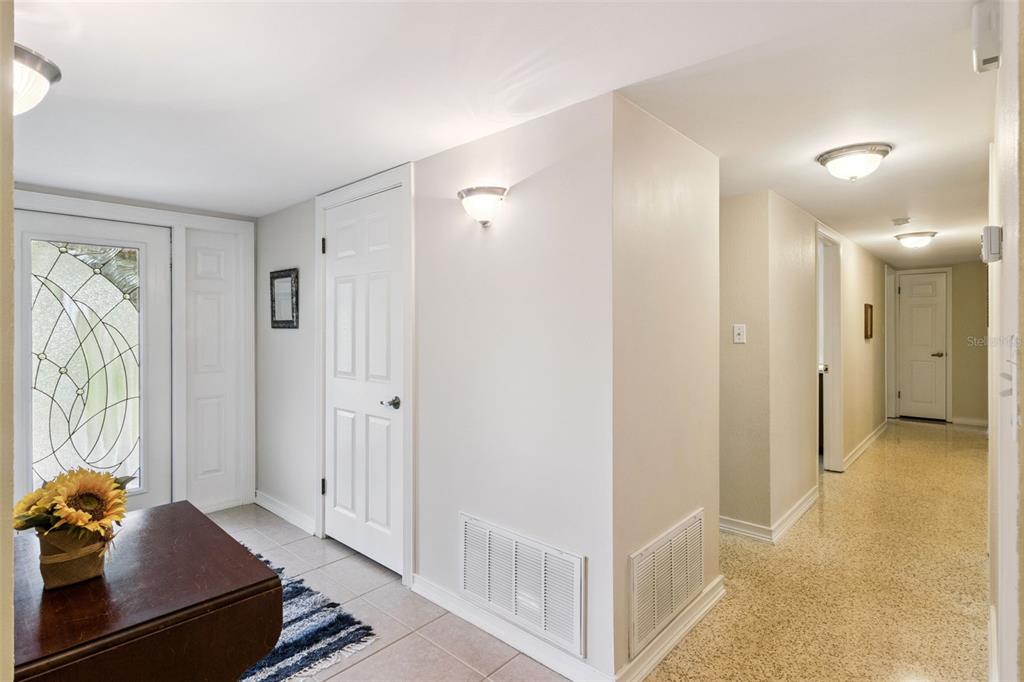 A bright entryway with a glass-paneled front door, tiled floors, and a long hallway beyond — 101 RONELE DRIVE, BRANDON, FL
