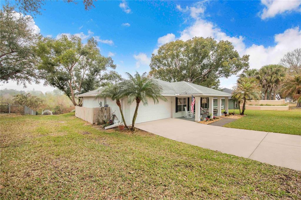A single-story house with a white exterior, a two-car garage, and a front porch — 194 S LAKE MARIAM DRIVE, WINTER HAVEN, FL