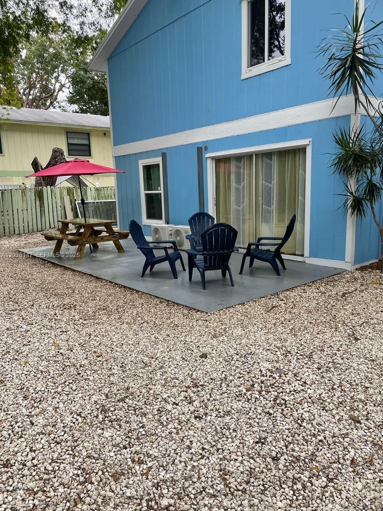 A blue house exterior features a patio with a picnic table and four chairs — 710 Barcelona Rd, Key Largo FL 33037, KEY LARGO, FL