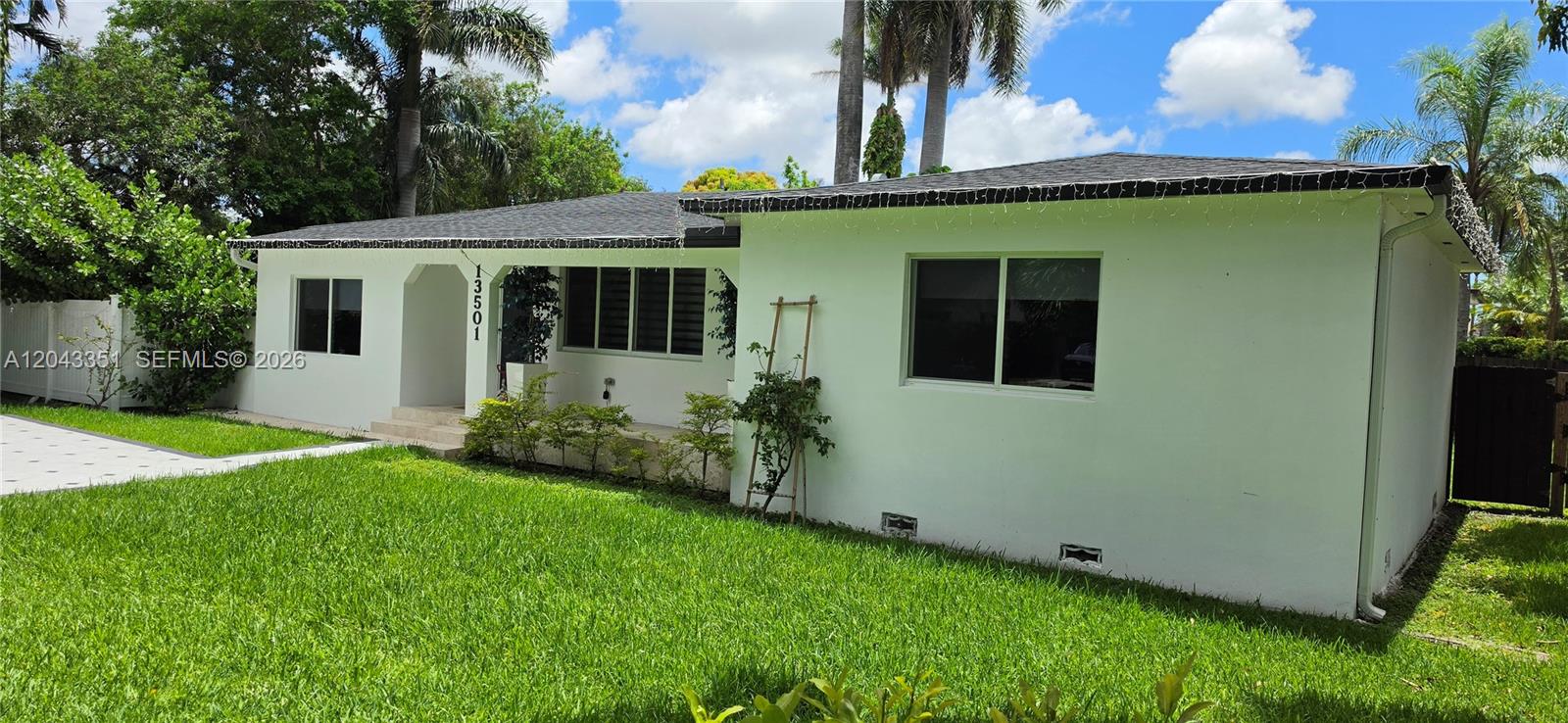 A single-story white house with a lawn, palm trees, and a covered front entryway — 13501 NE Miami Ct, Miami FL 33161, MIAMI, FL