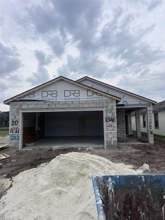A single-story house under construction features concrete block walls and a large open garage — 3346 CUP DRIVE, LAKELAND, FL