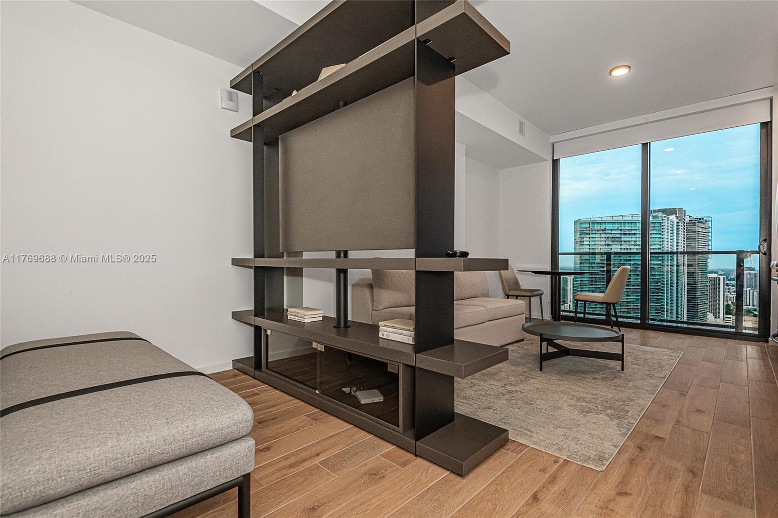 A modern living area features a dark wood room divider, light flooring, and floor-to-ceiling windows — 398 NE 5th St # 4008, Miami FL 33132, MIAMI, FL