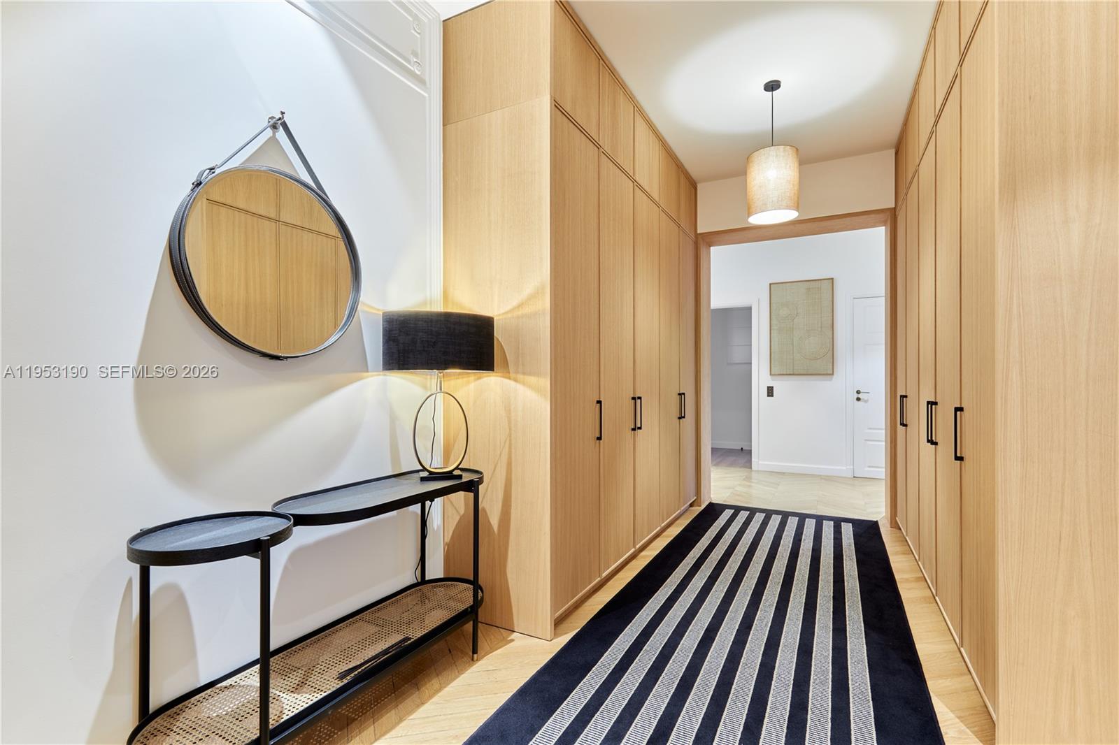 A hallway features light wood cabinetry, a striped runner rug, and a console table — 11 Rue St Dominique # 403, FR, FR
