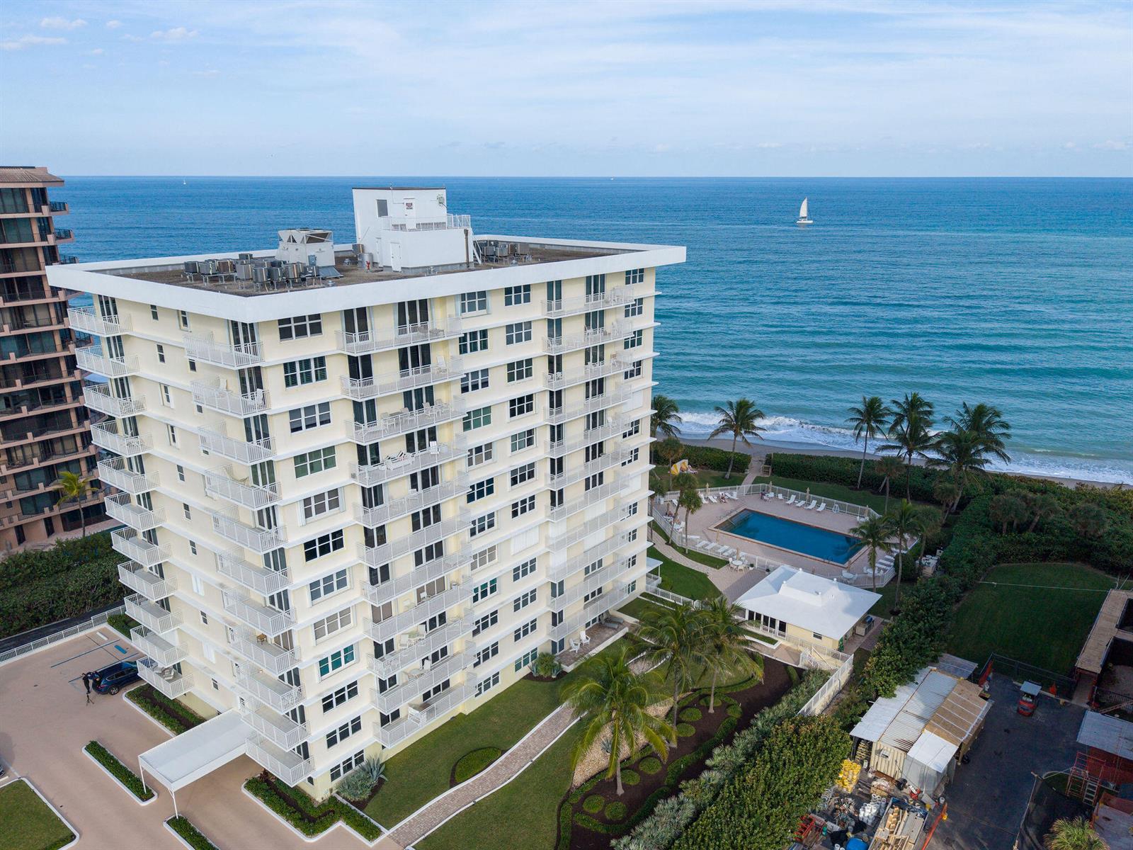 An aerial view of a multi-story apartment building with a swimming pool near the ocean — 500 Ocean Drive # 2d, Juno Beach FL 33408, JUNO BEACH, FL