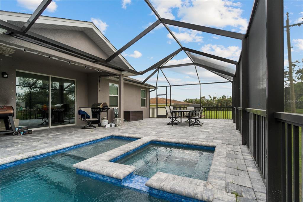 A paved patio features a pool and spa enclosed by a screened-in lanai structure — 265 ANNAPOLIS LANE, ROTONDA WEST, FL