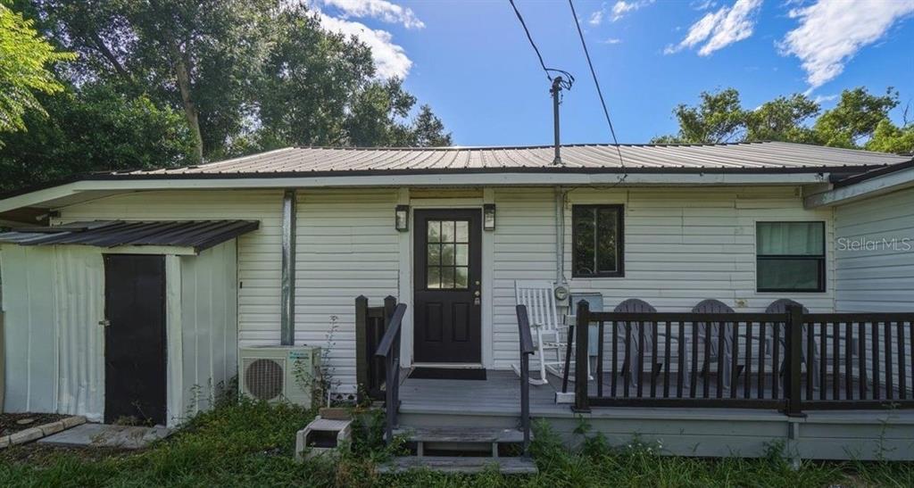 A white house with a metal roof, a front porch, and a small storage shed — 650 9TH STREET NE, WINTER HAVEN, FL