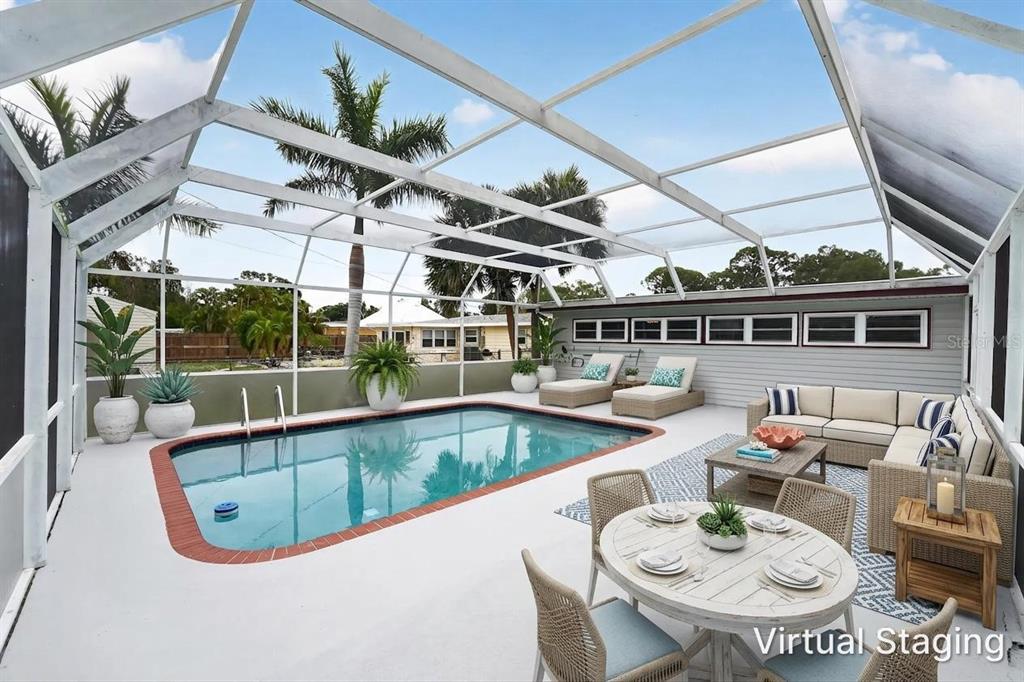 A screened-in patio features a swimming pool, outdoor seating, and a dining area — 2505 WOOD STREET, SARASOTA, FL
