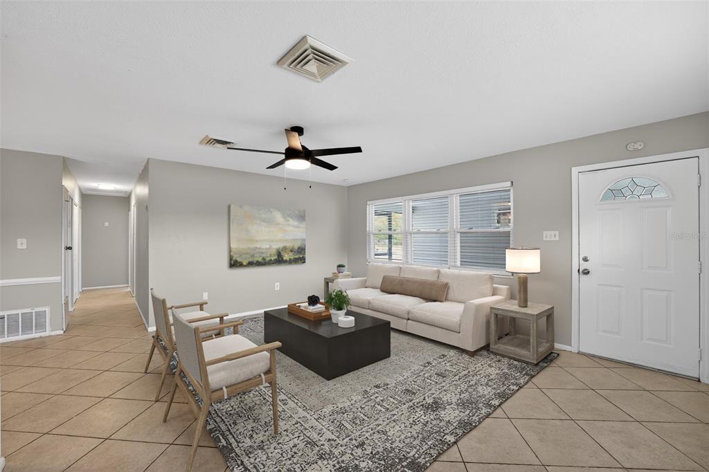 A living room features a beige sofa, two wooden chairs, a coffee table, and tile flooring — 2505 WOOD STREET, SARASOTA, FL