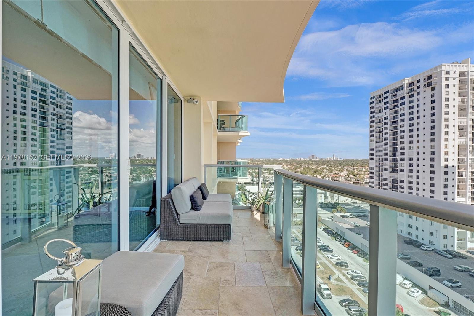 A balcony with tile flooring, outdoor furniture, and a glass railing overlooks a city view — 2501 S Ocean Dr # 1510, Hollywood FL 33019, HOLLYWOOD, FL