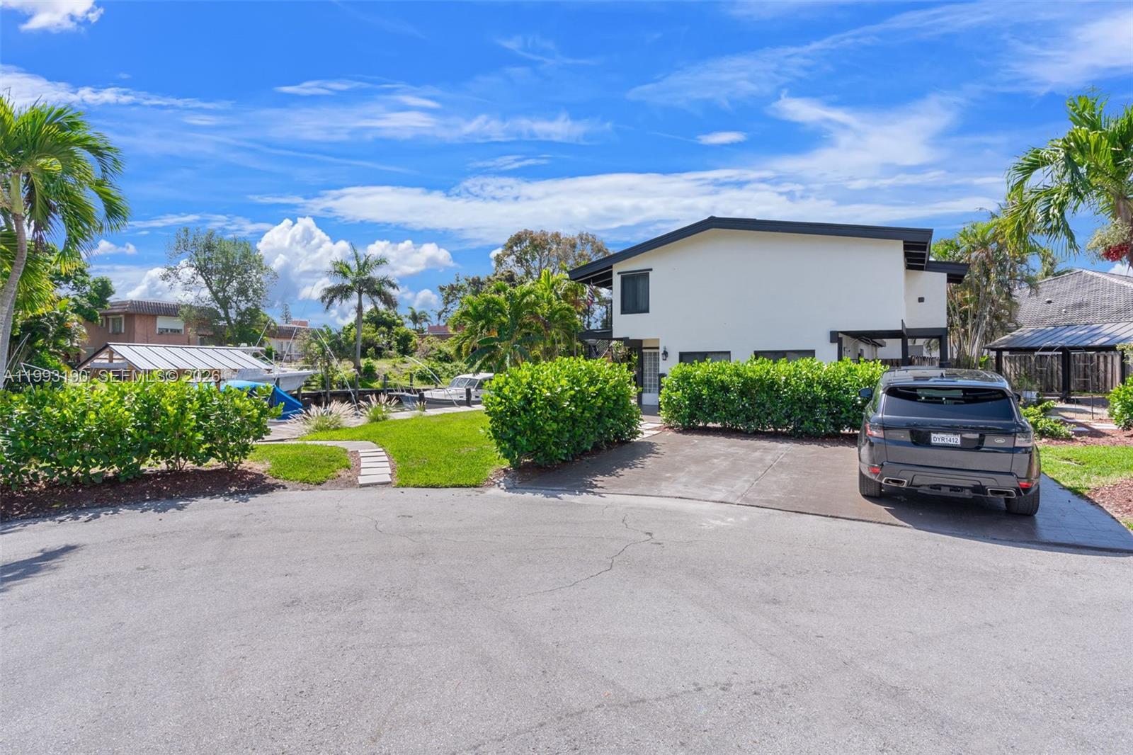 A two-story house with a driveway and a boat docked in the canal behind it — 516 NE 6th Ave, Deerfield Beach FL 33441, DEERFIELD BEACH, FL