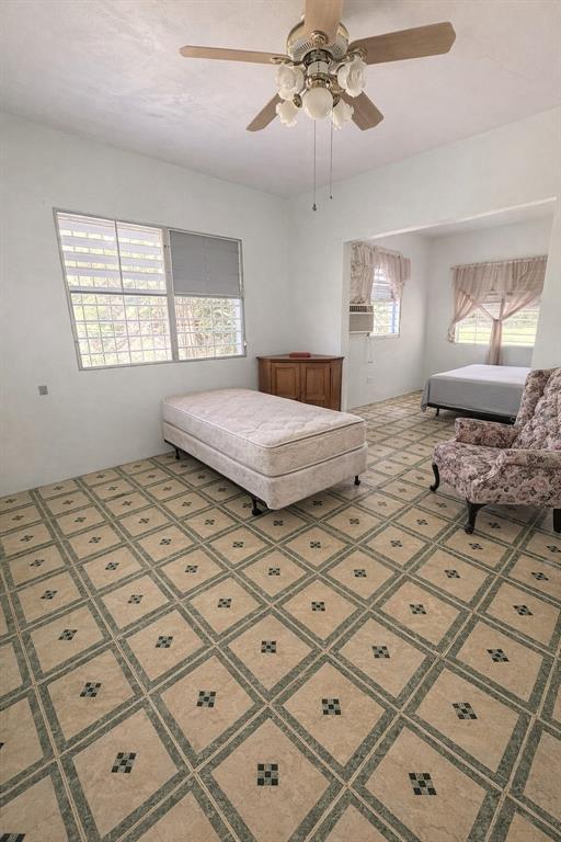 A bedroom with tiled floors, a ceiling fan, a single mattress, and an armchair — PR 1 19.9, SAN JUAN, PR