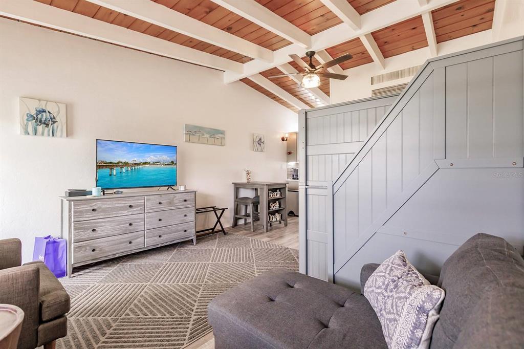 A living room features a vaulted wood-beam ceiling, a grey dresser, and a grey sofa — 6006 MIDNIGHT PASS ROAD UNIT 2, SARASOTA, FL