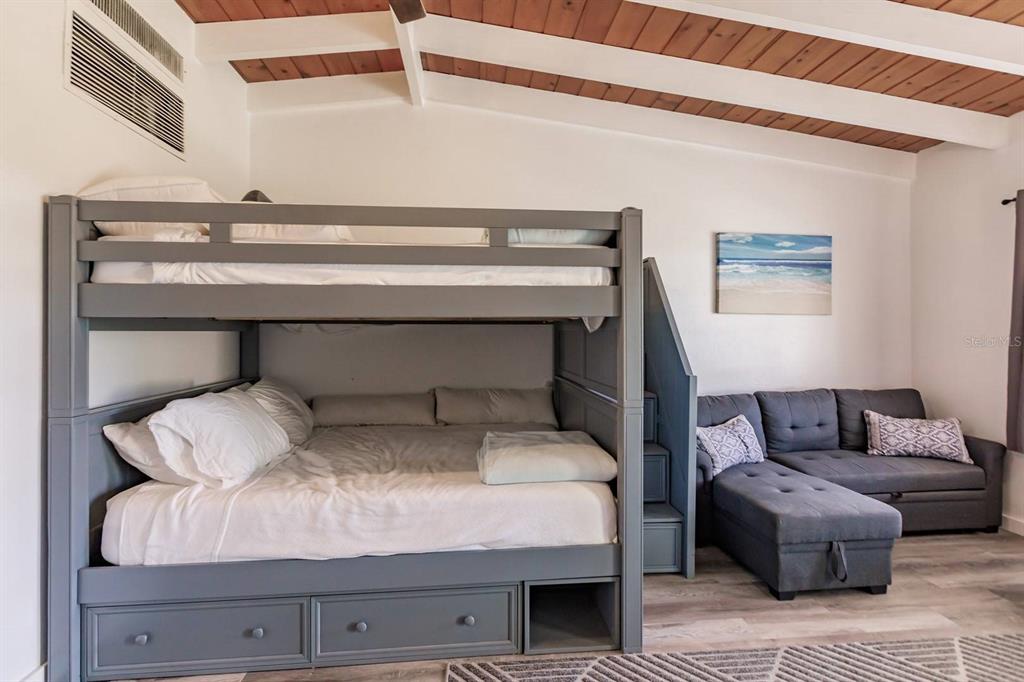 A bedroom features a gray bunk bed with storage drawers and a matching sectional sofa — 6006 MIDNIGHT PASS ROAD UNIT 2, SARASOTA, FL