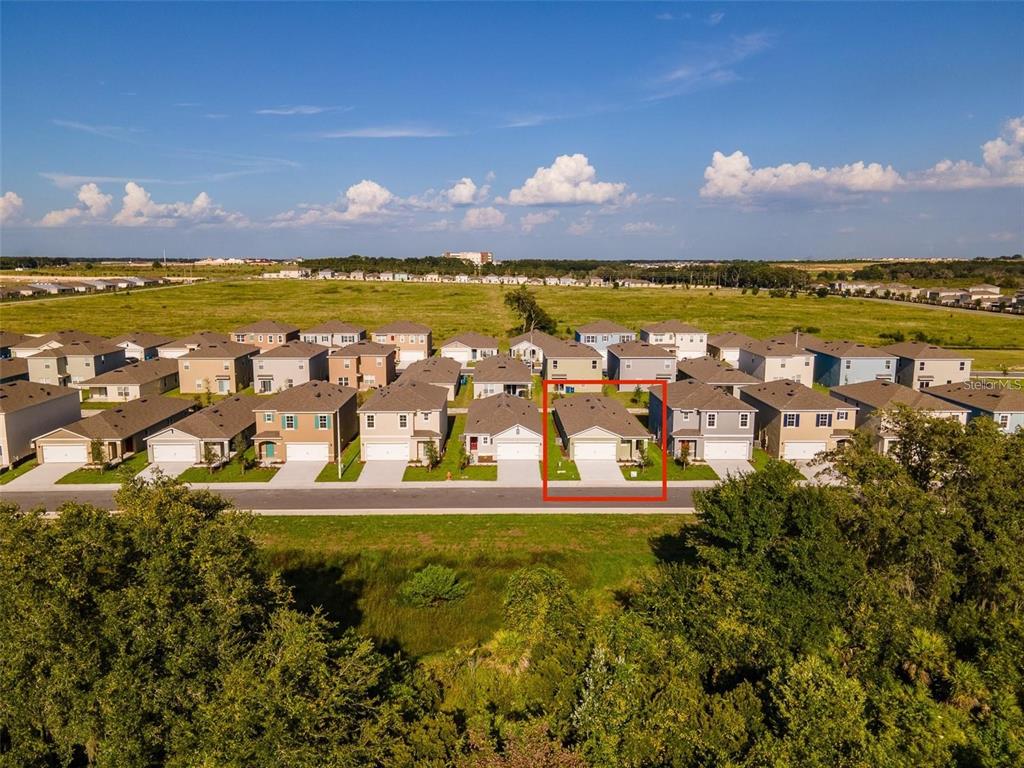 An aerial view shows a suburban neighborhood with rows of houses and a red-outlined home — 2464 RIBBON FALL AVENUE, DAVENPORT, FL