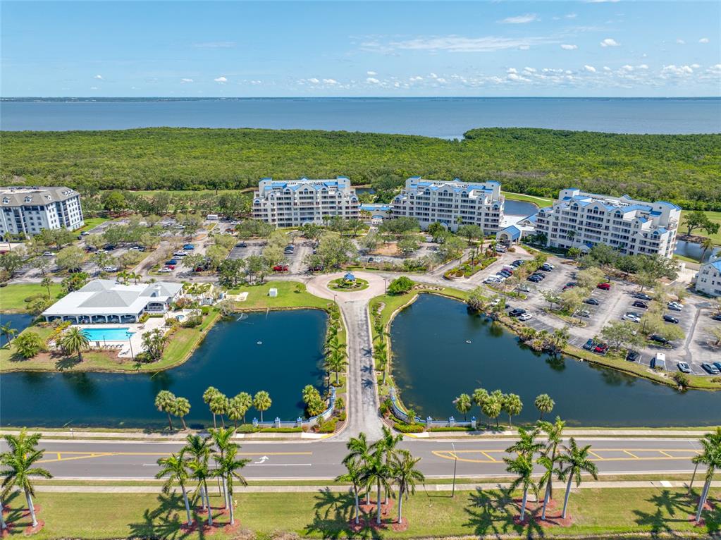 An aerial view shows a multi-building residential complex with a pool and two ponds — 2333 FEATHER SOUND DRIVE UNIT A107, CLEARWATER, FL